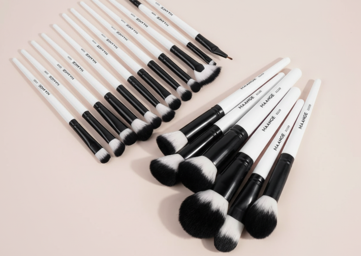 Black and white MAANGE brushes arranged - soft pink background